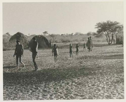 Group walking in the Chukudu village in the space between huts