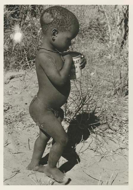 Child walking holding a can