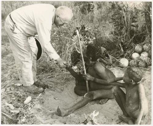 Laurence Marshall shaking hands with Oukwane, /Gaiamakwe sitting (print is a cropped image)