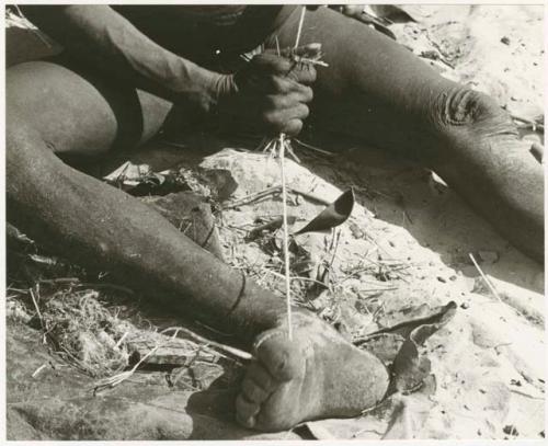 Oukwane holding cord in his toes, stretching cord (print is a cropped image)