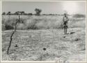 /Twikwe in a clearing holding a pan