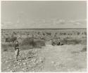 Elizabeth Marshall Thomas standing by the road, a truck going down a hill (print is a cropped image)