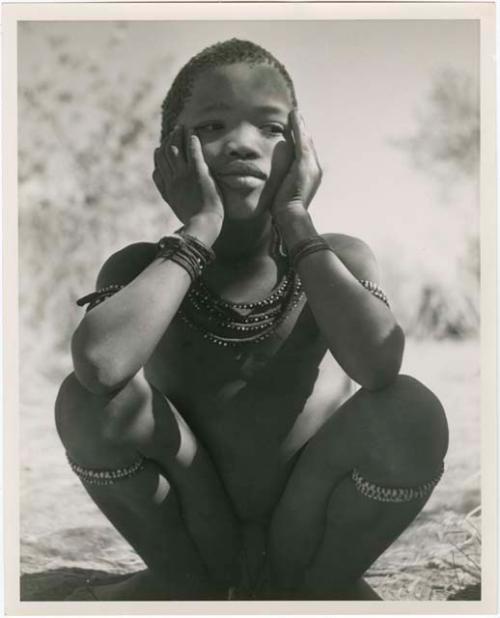 "Individuals I [Lorna Marshall] can't identify": Boy sitting, with his hands on his cheeks (print is a cropped image)