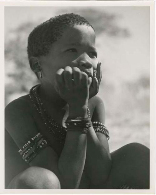 "Individuals I [Lorna Marshall] can't identify": Boy sitting, with his hands on his cheeks (print is a cropped image)