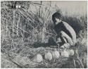 [No folder title]: ≠Gao (leader of Band 10) at a waterhole, with 5 ostrich egg shells next to him (print is a cropped image)