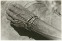 /Twikwe's hand with bracelets, close-up (print is a cropped image)