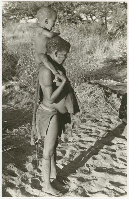 Tsekue carrying N!whakwe on her shoulders (print is a cropped image)