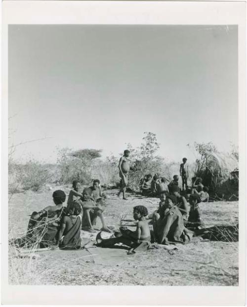 "Gao Medicine extended family, Band 1": N!ai playing a //guashi, with a group of people sitting with her