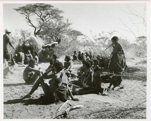 [No folder title]: Group of Ju/'hoansi sitting in "Gao Medicine's" werft, including his father, Khuan//a (his sister) and her husband, //Ao (print is a cropped image)