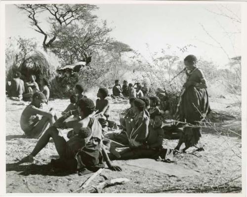 [No folder title]: Group of Ju/'hoansi sitting in "Gao Medicine's" werft, including his father, Khuan//a (his sister) and her husband, //Ao (print is a cropped image)