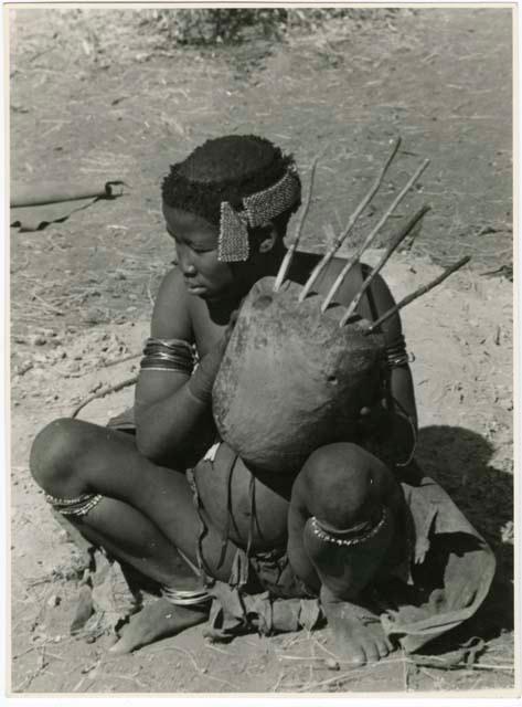 [No folder title]: //Kushay ("Gao Helmet's" second wife) sitting and playing the //guashi (print is a cropped image)