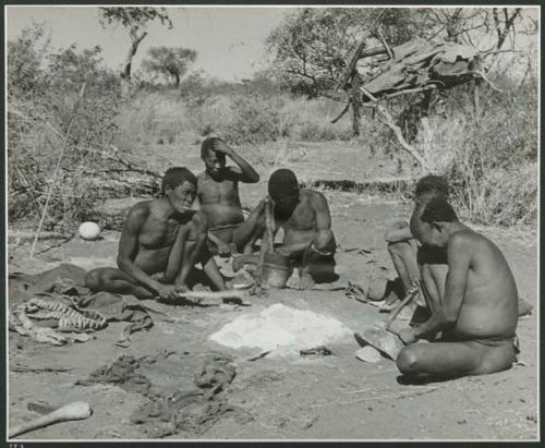 Groups [of] men: Group of men sitting around a fire, talking and working, including "Old Gau" (Band 1), ≠Gao (husband of Khwo//o-/Gasa and brother of "Old Gau"), /Gaishay, and "Qui /Navel" (print is a cropped image)