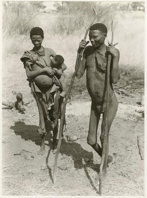 "Lame !Kham": !Kham with sticks as crutches and his wife, Be, carrying their nursing baby (print is a cropped image)