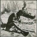 "Band 2, Gao Helmet #28": "Gao Helmet" shaping an assegai blade, and sitting with his second wife //Kushay (print is a cropped image)