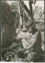 [No folder title]: //Kushay ("Gao Helmet's" second wife) pounding with mortar and pestle (print is a cropped image)