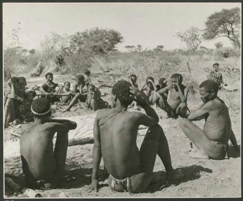 [No folder title]: "Gao Hunchback" with his hand to his face, sitting with the members of his band (print is a cropped image)