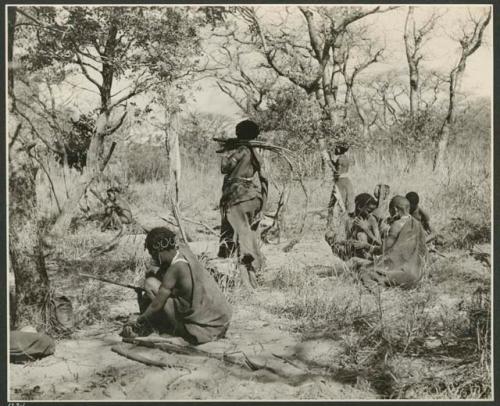 [No folder title]: Women gathering long orange roots from which they make fiber cord (print is a cropped image)