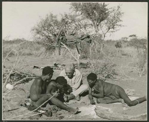 [No folder title]: ≠Toma mending Laurence Marshall's boot, and "Old Gau" and "Gao Medicine" watching him (print is a cropped image)