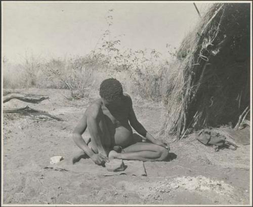 Man sitting in front of a skerm smoothing something, possibly an arrow foreshaft