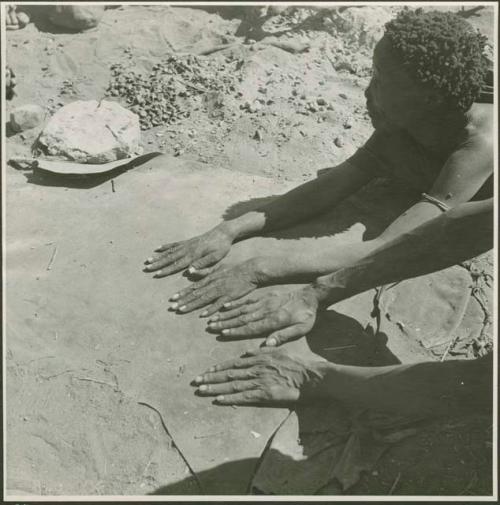 /Naoka (wife of "Gao Medicine) and a man putting their hands on a kaross