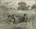 Group of people crouching at the waterhole

