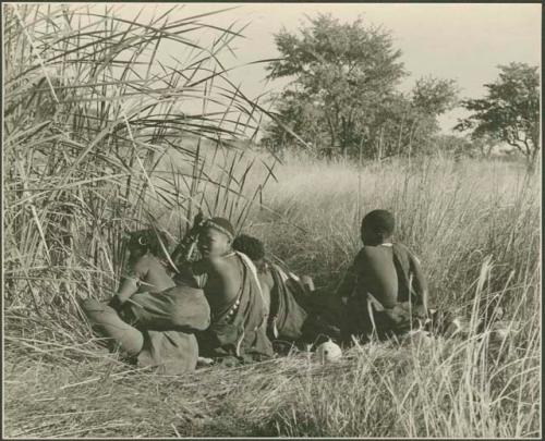 Group of people crouching at the waterhole

