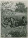 Group of people crouching at the waterhole

