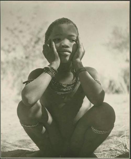 Boy sitting, with his hands on his cheeks





