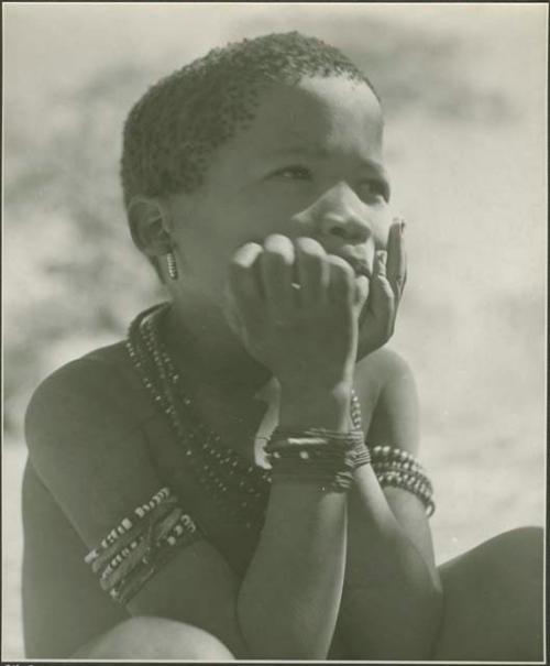 Boy sitting, with his hands on his cheeks



