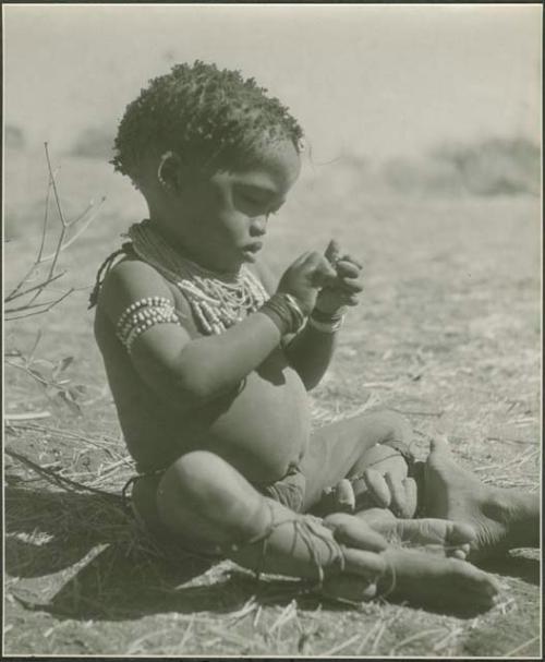 "Little /Gaishay" (son of Di!ai and "Gao Medicine") wearing rattles


