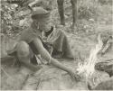 Young woman sitting by a fire