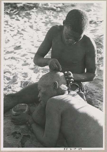 !Gai seated, cutting another man's hair





