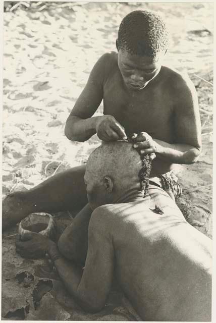 !Gai seated, cutting another man's hair



