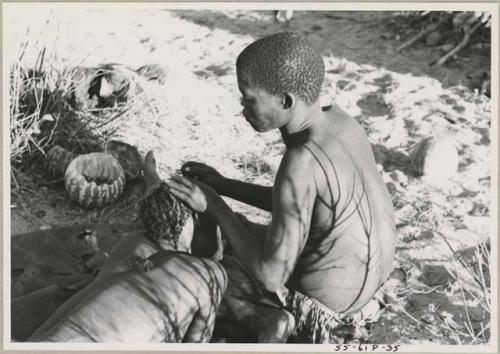 !Gai seated, cutting another man's hair
