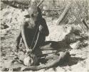 Oukwane playing a musical bow, seated
