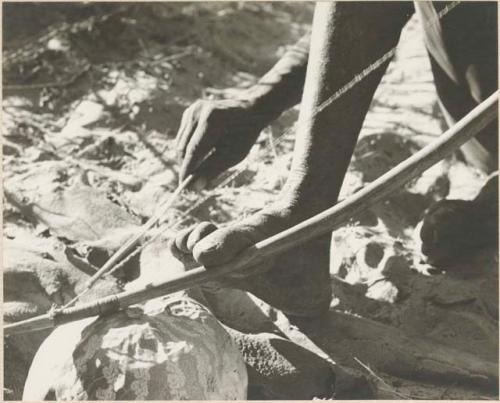 Close-up of Oukwane's hands playing a musical bow