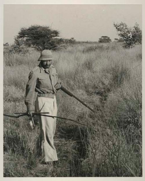 Robert Story standing and holding a gun
