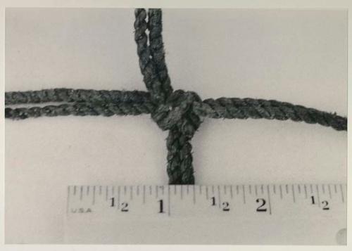 Knot in carrying net, close-up, with a ruler for measurement
