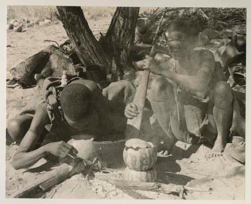 /Twikwe and DaSi!Na cooking with two tsama melons used as a double boiler
