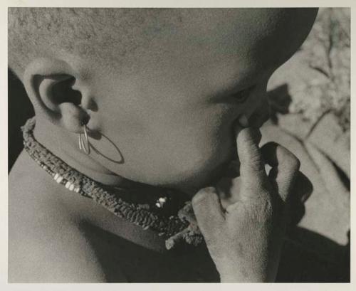 N!whakwe wearing an earring, close-up