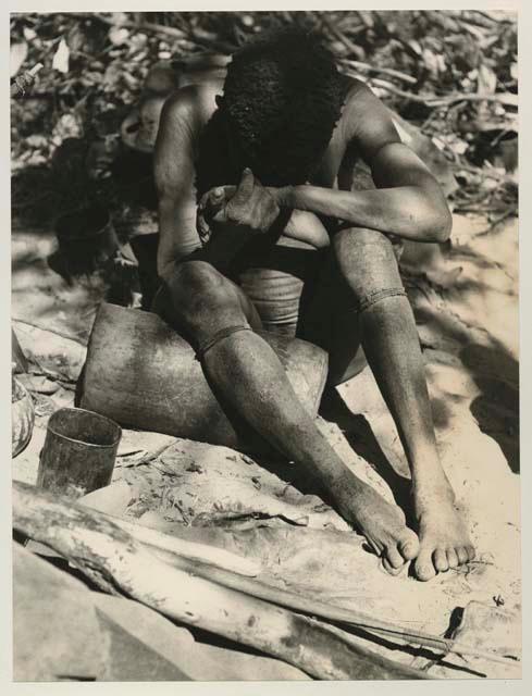 Woman sitting and resting her knee on a mortar