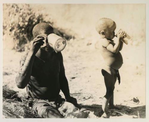 !Gai and N!whakwe each drinking respectively from a tin and a bowl