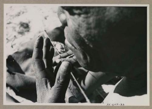 Close-up of Oukwane's hands showing playing a bow
