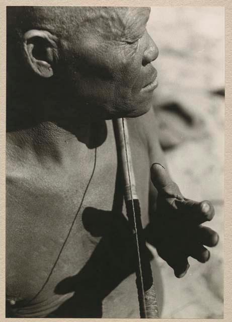 Close-up of Oukwane's hand demonstrating how to play a musical bow

