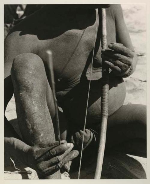 Close-up of Oukwane demonstrating how to play a musical bow

