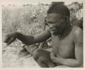 Visiting man demonstrating huntinghand signals, half figure seated