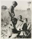 N!whakwe standing on his mother Tsekue's shoulders
