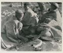 Group of visiting women in their werft making a fire, wrapped in karosses

