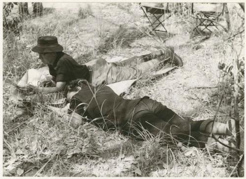 [No folder title]: Lorna Marshall and Elizabeth Marshall Thomas lying on the ground resting (print is a cropped image)