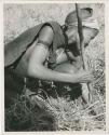 Digging for roots: /Naoka digging for a root in the grass with her digging stick (print is a cropped image)